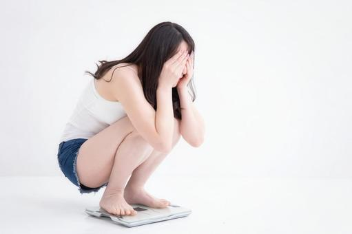 体重計に乗る女性の画像